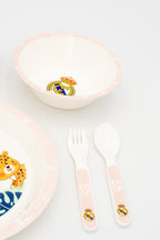 Cuenco y cubiertos rosas con el escudo del Real Madrid y detalles decorativos perimetrales.