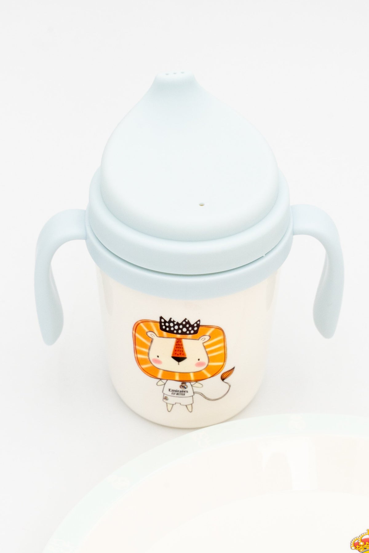 Vaso de aprendizaje azul con asas ergonómicas y tapa protectora para alimentación infantil.